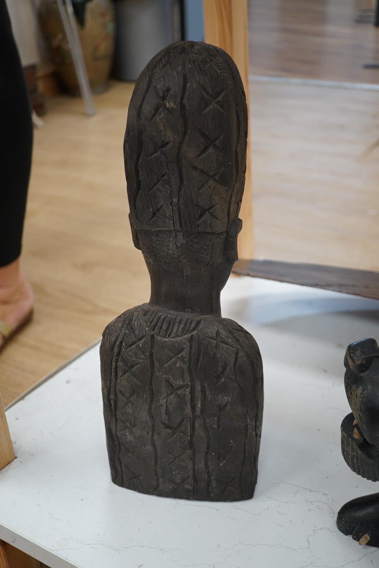 An African hardwood carving of a bust, 41cm high and an ebony Indian carving of a lion, 35cm long, (2). Condition - fair